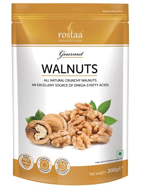 roasted walnuts with green leaves in a bag on a white background, front ...