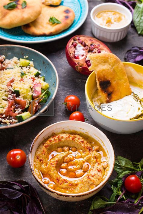 Royalty Free Image | Table served with middle eastern vegetarian dishes. Hummus, tahini, pitta ...