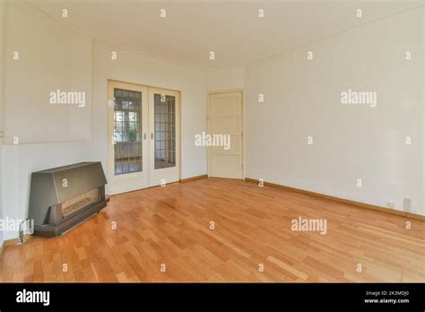 Empty modern room next to a fireplace and parquet floor Stock Photo - Alamy