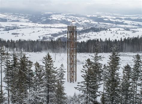 the tower overlooks the vast forested mountains and surrounding ski slopes.