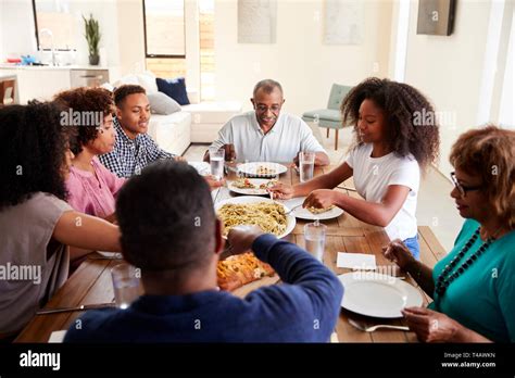 Three generation black family sitting at dinner table eating together, elevated view Stock Photo ...