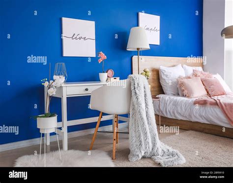 Interior of modern bedroom with blue wall Stock Photo - Alamy