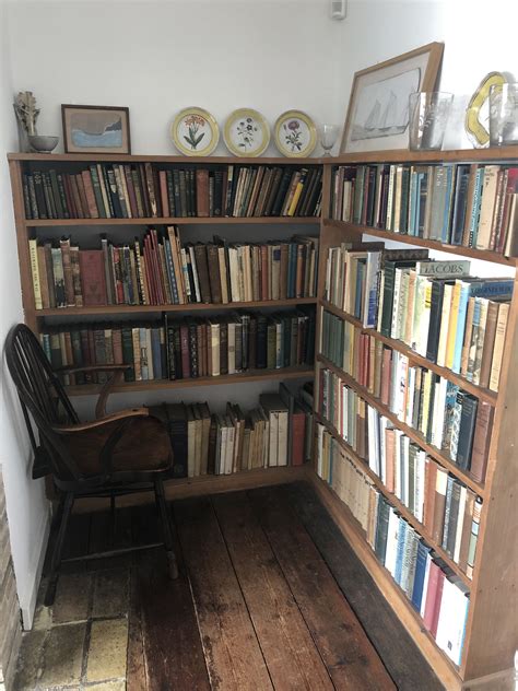 a bookshelf filled with lots of books next to a chair