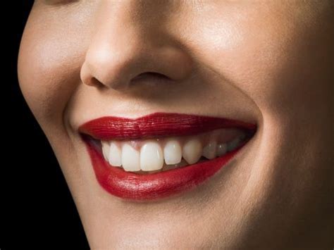 Female with red lipstick smiling, close up