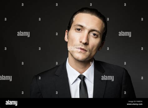 portrait of an attractive mysterious man in black suit and tie on dark background Stock Photo ...