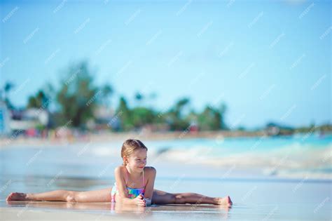 Premium Photo | Adorable little girl lying in shallow water on white beach