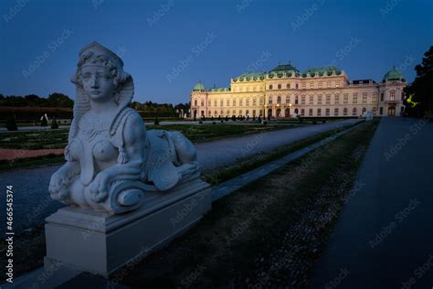 Famous Belvedere castle (Schloss Belvedere) surrounded by gardens with classic statues at night ...