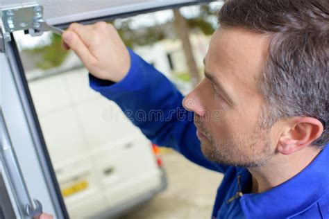 Man installing garage door stock photo. Image of metal - 103746396