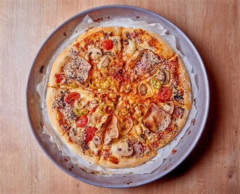 Premium Photo | A pizza with mushrooms and cheese on it is on a wooden table.