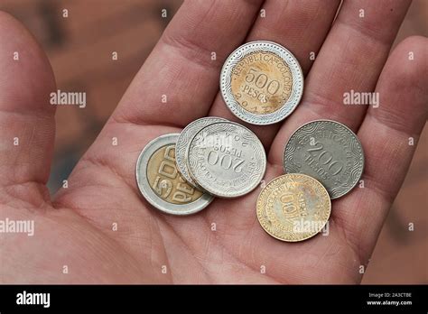 Colombian Peso Coins Held in HAnd Stock Photo - Alamy