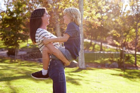 Loving mother hugging son in park - Stock Photo - Dissolve