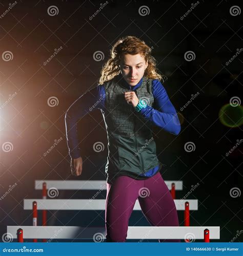 Young Female Athlete Training Running with Hurdles Stock Photo - Image ...