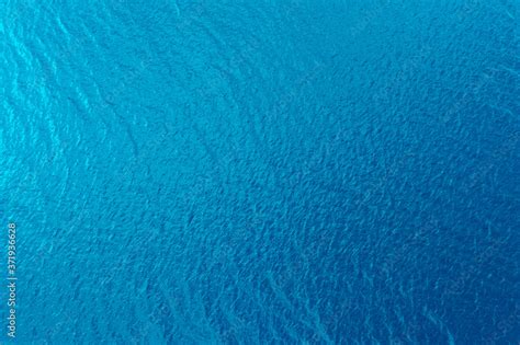 Aerial view of a crystal clear sea water texture. View from above Natural blue background. Blue ...