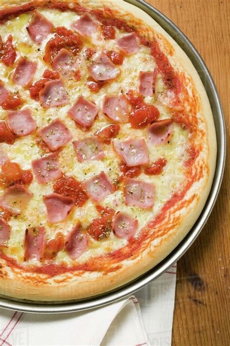 Ham, cheese and tomato pizza (detail) - Stock Photo - Dissolve