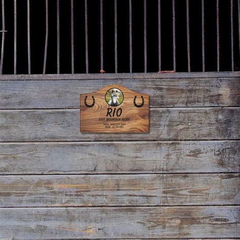 a wooden sign on the side of a building with metal bars in front of it