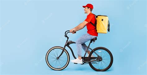 Premium Photo | Male Courier Riding Bike Posing With Backpack Bag Blue Background