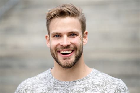 Man with perfect brilliant smile unshaven face defocused background. Guy happy emotional ...