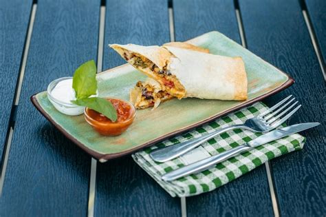 Premium Photo | Mexican burrito on plate on wooden background