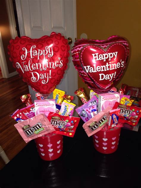 two valentine's day candy buckets with heart shaped balloons