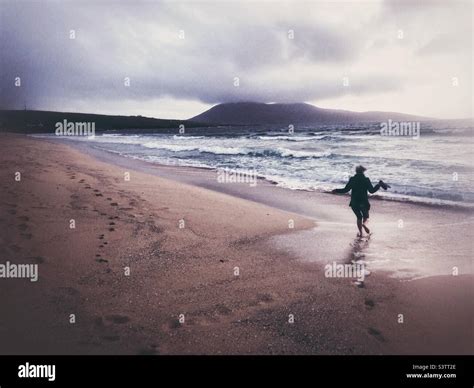 Running barefoot on the beach Stock Photo - Alamy