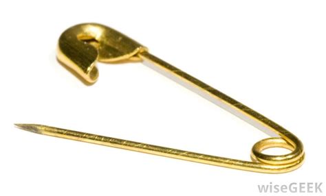 a gold pin with a heart on the end and a hook attached to it's side