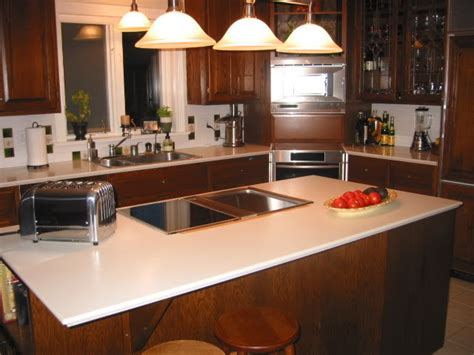 a kitchen with wooden cabinets and white counter tops, along with an island in the middle