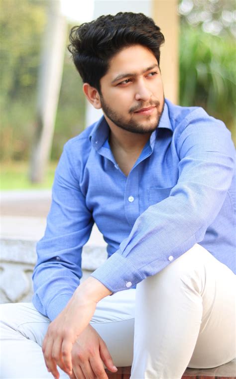 Man in blue dress shirt and white pants sitting on concrete bench ...