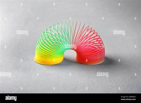 Rainbow slinky on grey background Stock Photo - Alamy