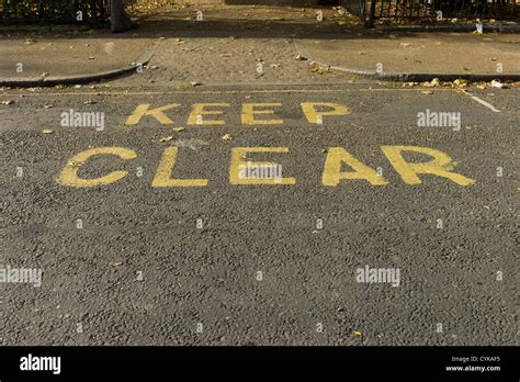 Yellow Keep Clear road sign, written on road at entrance to park in Lincoln's Inn Fields ...