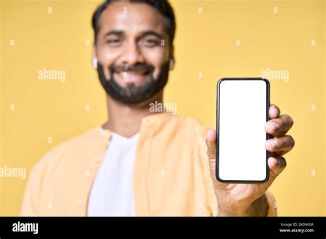 Happy indian man showing mobile phone mockup screen isolated on yellow Stock Photo - Alamy