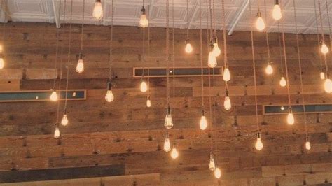 the light bulbs are hanging from the wood wall in the restaurant's ...