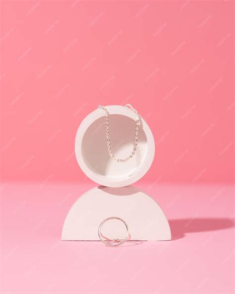 Premium Photo | Jewelry on a pink background stylish silver rings and necklace with different design