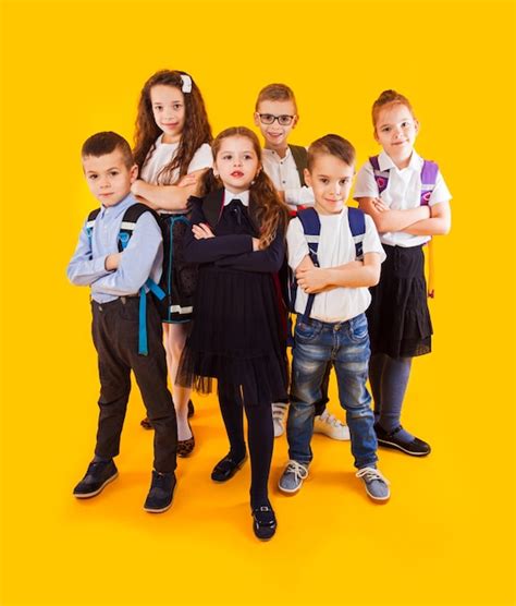 Premium Photo | Group of happy kids in uniform with school bags hugging ...