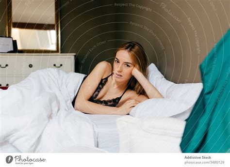 Young woman lying down in bed - a Royalty Free Stock Photo from Photocase