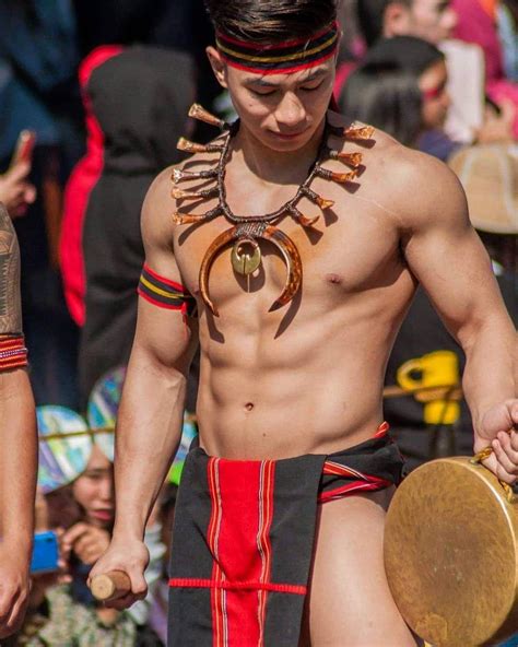 a man with no shirt on holding a wooden object