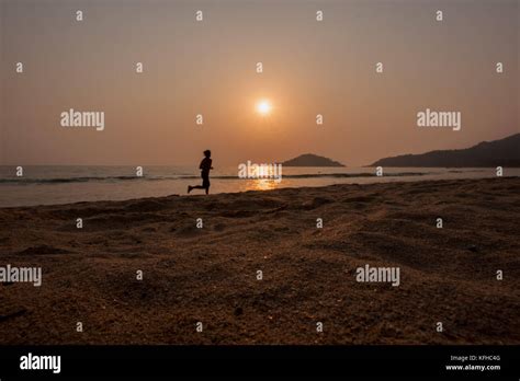 Running on the beach at sunset Stock Photo - Alamy