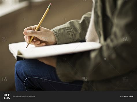 Person writing in a book stock photo - OFFSET