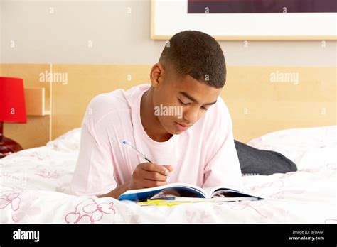 Teenage Boy Writing In Diary In Bedroom Stock Photo - Alamy