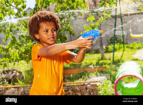 Boy playing water gun fight game with his friends Stock Photo - Alamy