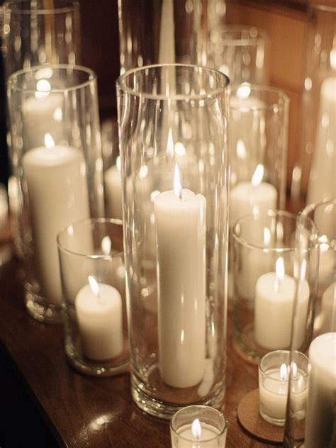 Lit White Pillar Candles in Cylinder Vases | Flameless candles wedding ...