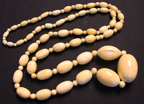 A single row necklace of graduated oval ivory beads alternating with ...