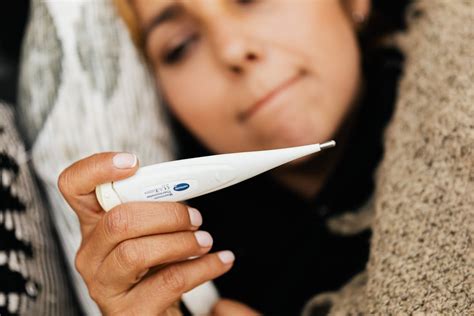 A Sick Woman Using a Digital Thermometer · Free Stock Photo