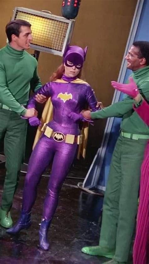 three men in green and purple costumes talking to each other on the set of batman