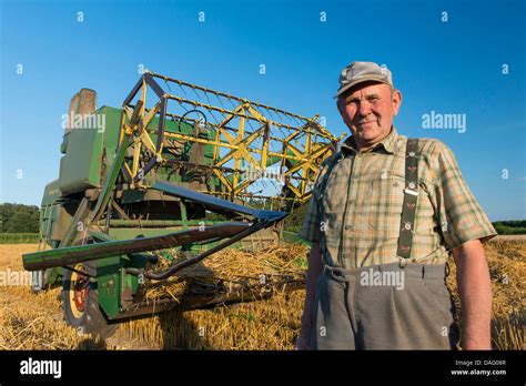 farmer in front of his old combine harvester in grain field, Germany ...