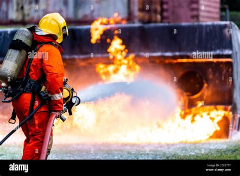 Firefighters spraying down fire flame from oil tanker truck accident Stock Photo - Alamy