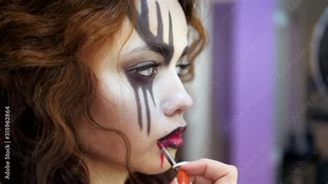 Easy Halloween Makeup. Applying makeup to the face. Drawing red blood on the face of a crying ...