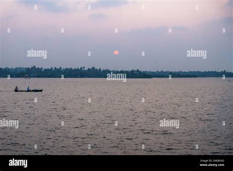 Purple sunset with fishing boat at the Ashtamudi Lake, Kollam, Kerala, India Stock Photo - Alamy