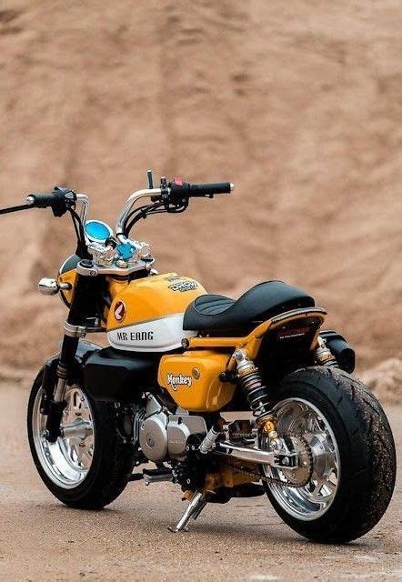 a yellow motorcycle parked on top of a dirt field