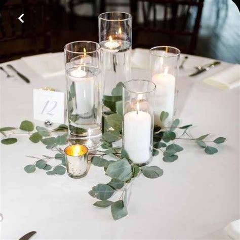 Pillar candles and greenery for centerpieces in 2024 | Candle wedding centerpieces, Beach ...