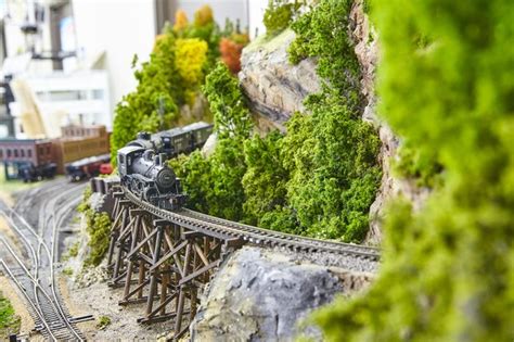 Premium Photo | Detailed miniature train set on trestle bridge with lush scenery